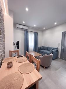 ein Wohnzimmer mit zwei Tischen und einer Couch in der Unterkunft Zeus & Emmanuil Luxury Houses in Mirina