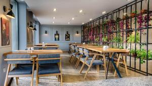 um restaurante com mesas de madeira, cadeiras e plantas em Gudauri Inn em Gudauri