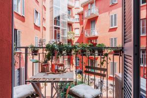 un balcón con una mesa con plantas. en New Jungle & Charming Flat - zona De Angeli en Milán