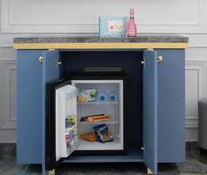 a blue kitchen island with an open refrigerator at Acropol Golden Suites in Neos Marmaras