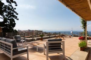 une terrasse avec des chaises et une table et l'océan dans l'établissement MARGHERITA 109, à Naples