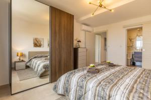 a bedroom with a bed and a large mirror at Dome Sunset Views Apartment in Mellieħa