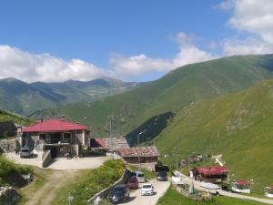 a building with a red roof in the mountains at Şahin Apart - Demirkapı - UZUNGOL in Çaykara