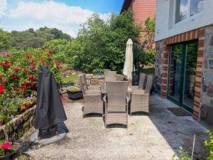 eine Terrasse mit Stühlen, einem Sonnenschirm und Blumen in der Unterkunft Ferienwohnung am Wurlsee in Lychen