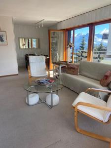 a living room with a couch and chairs and a table at Sunny mountain view apartment in town by Jolidi in Nendaz