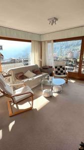 sala de estar con sofá, sillas y mesa en Sunny mountain view apartment in town by Jolidi, en Nendaz