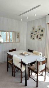 une salle à manger avec une table et des chaises blanches dans l'établissement Sunny mountain view apartment in town by Jolidi, à Nendaz
