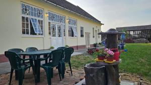 a patio with a table and chairs and a building at Kod Bake in Novi Bečej
