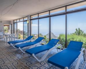 uma fila de cadeiras azuis num quarto com janelas em Lo mejor de la montaña, Vista Bonita Atico em Jama