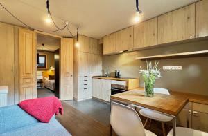 cocina con mesa y sillas y comedor en Alpini Apartamenty, en Zakopane