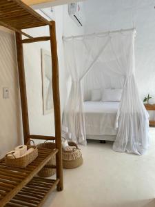 1 dormitorio con 1 cama con dosel y cestas en Pousada Jardim da Praça, en Caraíva