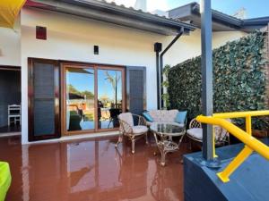 a house with a patio with a table and chairs at O CANTINHO DA RIA - JACUZZI with water at 35 degrees and POOL in Torreira +62 photos