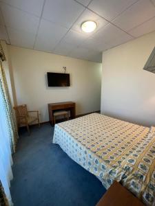 ein Schlafzimmer mit einem Bett und einem TV an der Wand in der Unterkunft Hotel Agrelo in Reboredo