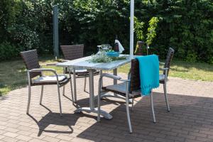 - une table avec des chaises et un parasol sur la terrasse dans l'établissement Villa-Meehr, à Bantikow