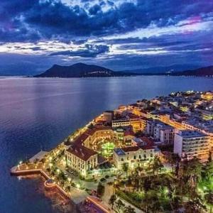 an aerial view of a city by the water at night at Saint George Hotel in Loutra Edipsou