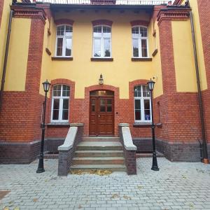 a building with two benches in front of a door at Szewczenki 3 in Olsztyn