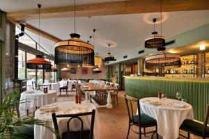 a restaurant with tables and chairs and a bar at GINGER Hotel in Tbilisi City