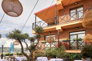 a building with tables and chairs in front of it at GINGER Hotel in Tbilisi City