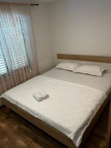a bed with two white towels on top of it at Apartman Hana in Brtonigla