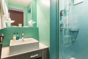 ein Bad mit einem Waschbecken und einer Dusche in der Unterkunft Hotel Platzhirsch in Zürich