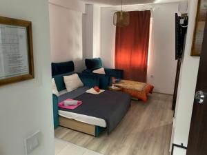a small room with a bed and a couch at De Lux Nedeljkovic in Jagodina