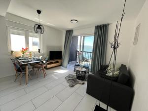 a living room with a table and a dining room at Apartmani Ora in Komarna