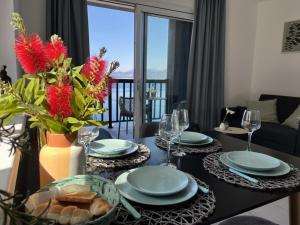 a dining room table with plates and wine glasses at Apartmani Ora in Komarna
