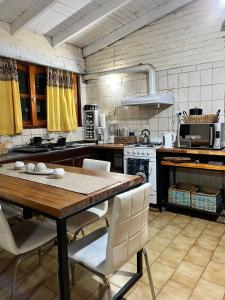 cocina con mesa de madera y sillas blancas en CASA FRENTE A PLAZA PRINCIPAL en Federación