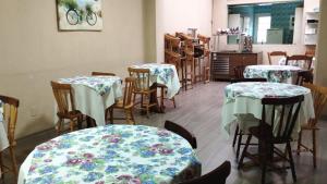 a dining room with tables and chairs with flowers on them at Novohotel Express in Santana do Livramento