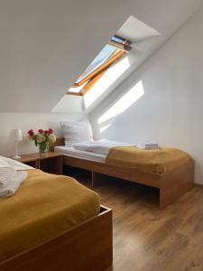 sypialnia na poddaszu z 2 łóżkami i oknem w obiekcie Gościniec Mazur w Krutyniu
