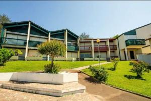a large building with a grass yard in front of it at Caporizon-Baillenia-T1 Vue Montagne - Piscine St Jean de luz in Saint-Jean-de-Luz +20 photos