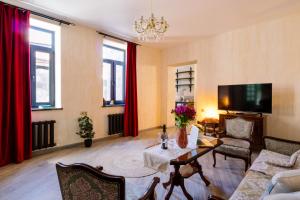 a living room with red curtains and a couch and a table at hotelise I Tuff Apartment in Gyumri