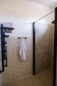 a shower with a white towel hanging on a wall at hotelise I Tuff Apartment in Gyumri