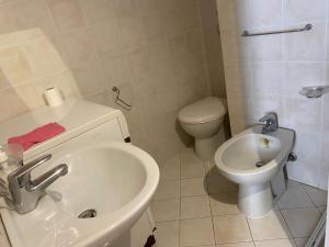 a white bathroom with a sink and a toilet at Casa di Tony in Trapani