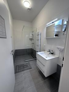 a white bathroom with a sink and a shower at Waldluft Apartments in Heidenreichstein +76 photos