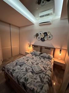 1 dormitorio con 1 cama con placas en la pared en Apartman S&V 4 Wellness & Spa Barda en Sarajevo