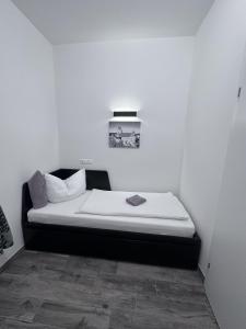 a bed in a room with a white wall at Waldluft Apartments in Heidenreichstein