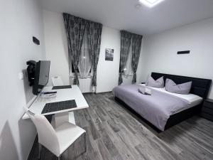 a bedroom with a bed and a desk with a computer at Waldluft Apartments in Heidenreichstein