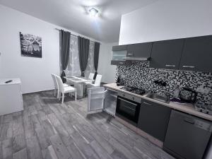 a kitchen with a counter and a table with chairs at Waldluft Apartments in Heidenreichstein