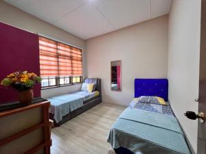Zimmer mit 2 Betten und einem Fenster in der Unterkunft Iman Homestay: Sri Kandis in Kuching