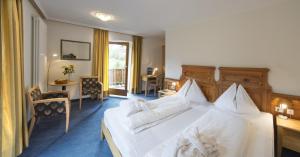 A bed or beds in a room at Dolomitenhotel Weisslahnbad