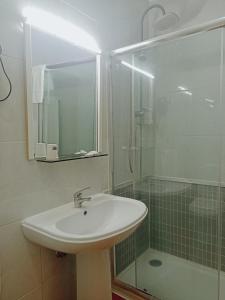 uma casa de banho com um lavatório e um chuveiro em Residencial Dona Teresa em Maia