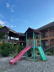a playground with a slide in front of a house at La Fontan in Sukhum