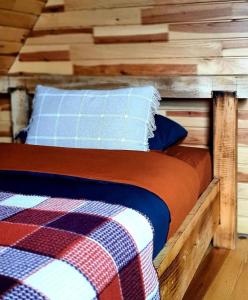 een bed in een blokhut met een deken en kussens bij bungalov in Rize