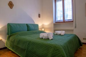 two towels on a green bed in a room at BouganVilla in Polignano a Mare