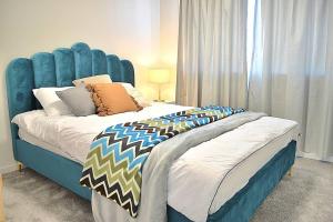 a large bed with a blue headboard in a bedroom at Elegant & Convenient New House at Leppington in Leppington