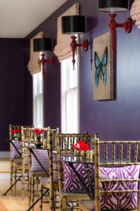 a dining room with purple walls and a table with chairs at Gilded in Newport