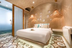 A bed or beds in a room at AMMOS at AmazeU Suites Naxos