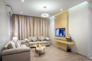 بودل الفيحاء في الرياض: غرفة معيشة مع أريكة وتلفزيون