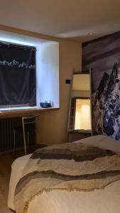 een slaapkamer met een bed, een bureau en een spiegel bij Cocooning in Arvier